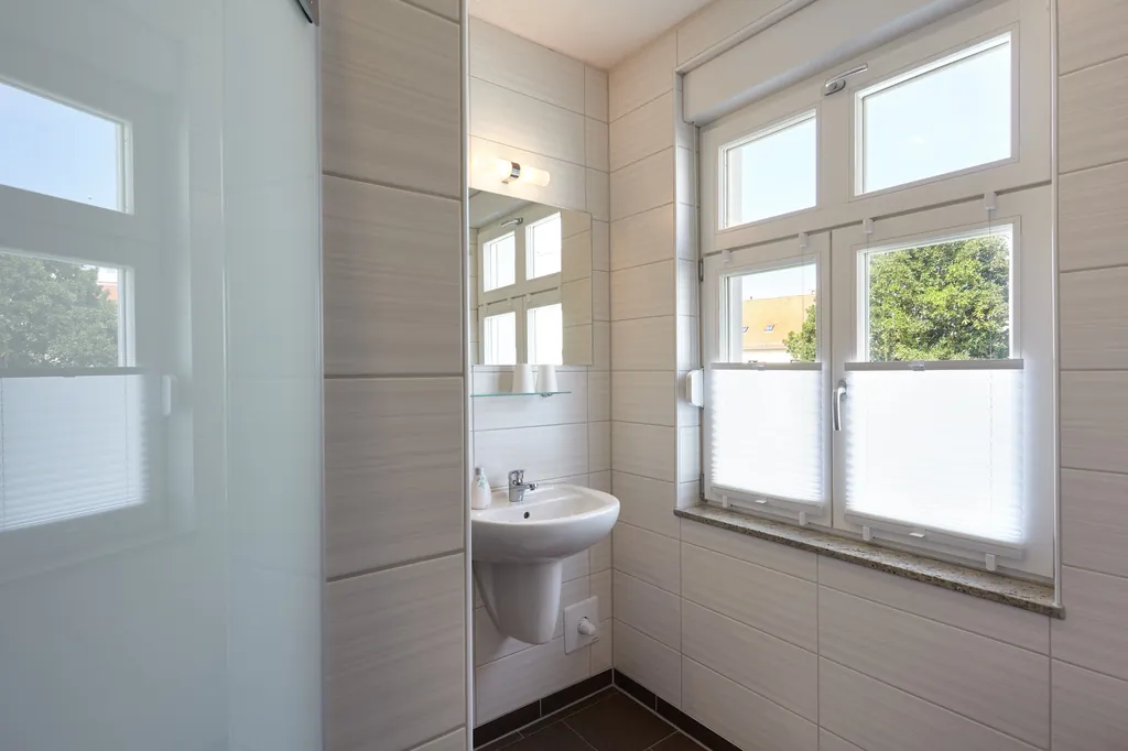 Bad mit Waschbecken und Fenster, Duschbereich mit Glaswand