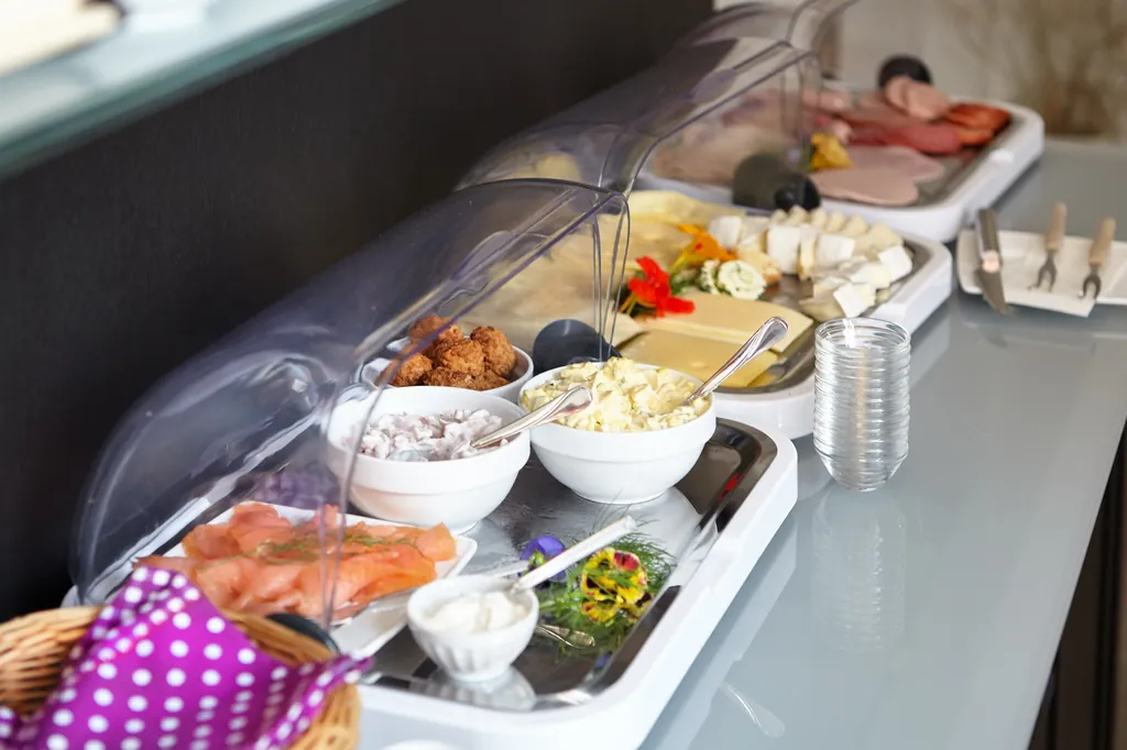 Frühstücksbuffet mit Aufschnitt, Käse und Lachs unter der Haube