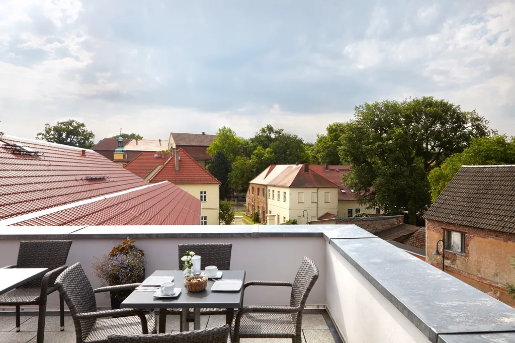 Dachterrasse mit gedeckten Tischen, Blick über die Dächer von Lieberose