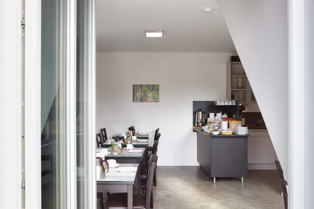 Frühstücksraum mit gedeckten Tischen und Buffet im Hintergrund